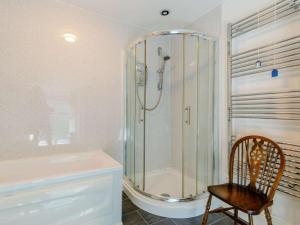 a bathroom with a shower and a wooden chair at 3 Bed in Conwy oc-85844 in Llanbedr-y-cennin +15 photos