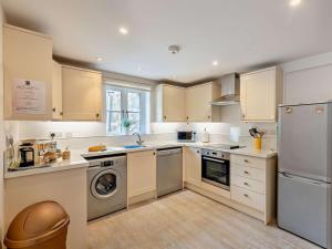 a kitchen with white cabinets and a washer and dryer at 2 Bed in Arthog oc-43105 in Arthog +12 photos