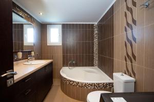 a bathroom with a tub and a toilet and a sink at Natural Quiet Accommodation 3 - Faliraki in Kalithies +33 photos