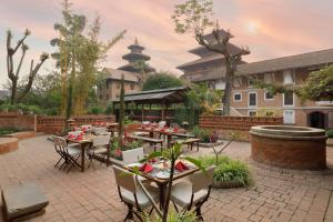 a patio with tables and chairs and a building at Hotel Himalaya Kathmandu - Your Business & Leisure Retreat in Kathmandu
