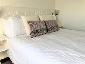 a white bed with two pillows on top of it at 2 Bed in Conwy oc-tycan in Llangelynin +6 photos