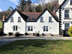 a white house with a black roof at 2 Bed in Conwy oc-tycan in Llangelynin