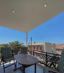 a patio with a table and chairs on a balcony at Fenareti Apartments in Skala Eresou