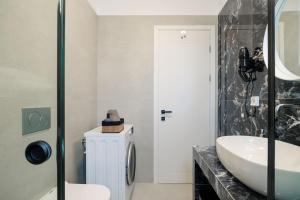 a bathroom with a sink and a toilet at Etherio Apartments Naxos in Galanádhon +58 photos
