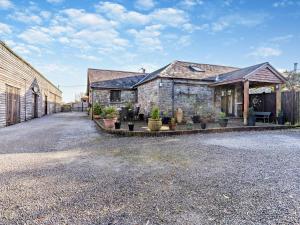 a stone house with potted plants in a driveway at 3 Bed in Swansea oc-93942 in Ilston