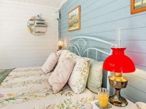 a bedroom with a bed with a red lamp and pillows at 1 Bed in Denbigh oc-91890 in Llanrhaiadr