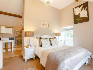 a bedroom with a white bed and a kitchen at 1 Bed in Corwen oc-52509 in Corwen