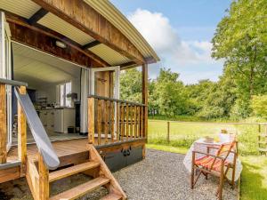 a tiny house with a porch and a table at 1 Bed in Kilgetty oc-88421 in Jeffreston