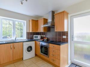 a kitchen with wooden cabinets and a washer and dryer at 3 Bed in Stepaside oc-fb047 in Stepaside