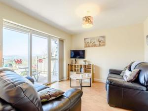 a living room with leather furniture and a large window at 2 Bed in Bala oc-86963 in Llandderfel