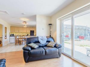 a leather couch in a living room with a sliding glass door at 2 Bed in Bala oc-86963 in Llandderfel +8 photos