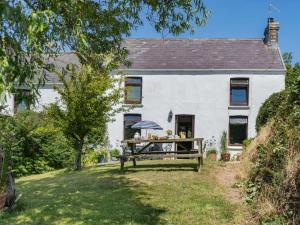 a white house with a picnic table in the yard at 2 Bed in Swansea oc-62019 in Reynoldston