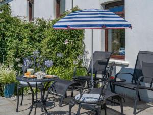 a table and chairs with an umbrella on a patio at 2 Bed in Swansea oc-62019 in Reynoldston +16 photos