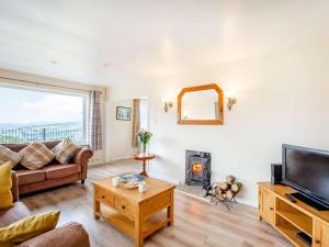 a living room with a couch and a fireplace at 4 Bed in Denbigh oc-62368 in Denbigh