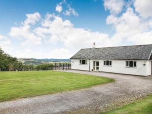 a white cottage with a large grass field at 4 Bed in Denbigh oc-62368 in Denbigh