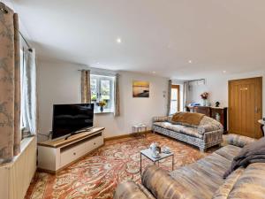a living room with a couch and a flat screen tv at 3 Bed in Arthog oc-77304 in Arthog