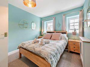 a bedroom with a large bed with blue walls at 1 Bed in Aberaeron oc-49261 in Aberaeron