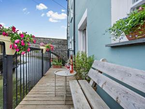 a wooden balcony with a table and a bench at 1 Bed in Aberaeron oc-49261 in Aberaeron