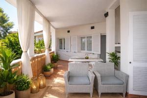 a patio with two chairs and a table and some plants at La Conia Sea View Retreat in Cannigione