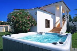 a hot tub in front of a house at La Conia Sea View Retreat in Cannigione +24 photos