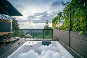 a bath tub in a room with a view at Bobocabin Coban Rondo, Malang in Songgoriti