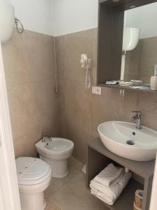 a bathroom with a sink and a toilet and a mirror at Acrita Superior in Mandaradoni +6 photos