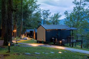 a small cabin in the woods with an umbrella at Bobocabin Coban Rondo, Malang in Songgoriti +38 photos