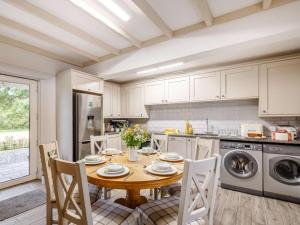 a kitchen with a wooden table with chairs and a dining room at 3 Bed in Bala oc-88351 in Frongoch