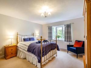 a bedroom with a bed and a blue chair at 3 Bed in Bala oc-88351 in Frongoch