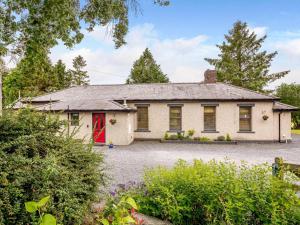 a house with a red door in a garden at 3 Bed in Bala oc-88351 in Frongoch