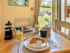 a table with a breakfast of croissants and orange juice at 1 Bed in Swansea oc-77980 in Penclawdd