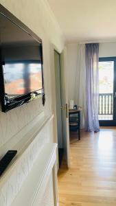 a living room with a flat screen tv above a fireplace at Comfort Doppelzimmer mit Balkon und Blick ins Grüne in Mespelbrunn