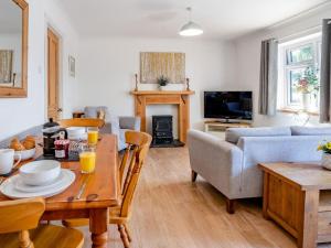 a living room with a table and a couch at 2 Bed in Swansea oc-77978 in Penclawdd