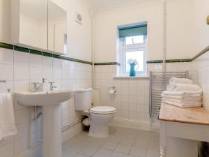 a white bathroom with a sink and a toilet at 2 Bed in Swansea oc-77978 in Penclawdd +22 photos