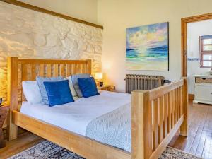 a bedroom with a wooden bed with blue pillows at 1 Bed in Swansea oc-77980 in Penclawdd