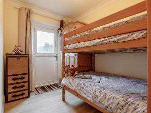 a bedroom with two bunk beds and a door at 2 Bed in Swansea oc-77978 in Penclawdd