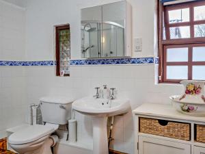 a white bathroom with a toilet and a sink at 1 Bed in Swansea oc-77980 in Penclawdd +29 photos