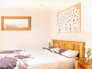 a bedroom with a bed and a mirror on the wall at 2 Bed in Narberth oc-36797 in Llawhaden