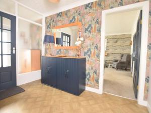 a living room with a blue cabinet and a wall at 2 Bed in Moelfre oc-75013 in Moelfre