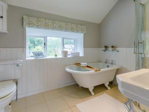 a white bathroom with a tub and a window at 3 Bed in Presteigne oc-78350 in Kinsham +34 photos