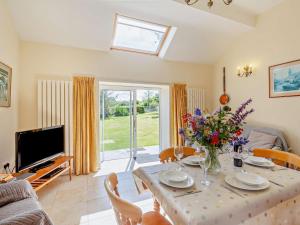 a living room with a table and a television at 2 Bed in Conwy oc-42573 in Llangelynin