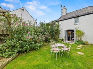 a table and chairs in the garden of a cottage at 2 Bed in Swansea oc-88216 in Port-Eynon