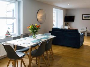 a living room with a table with chairs and a blue couch at 2 Bed in Tenby oc-fb284 in Tenby