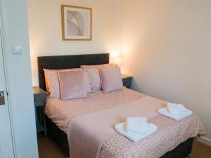 a bedroom with a bed with two towels on it at 2 Bed in Tenby oc-fb284 in Tenby