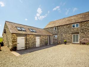 a stone barn with two garage doors and a driveway at 1 Bed in Corwen oc-52510 in Corwen