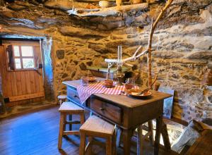 a wooden table in a room with a stone wall at Cardenha das Formiguinhas in Monção