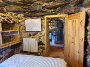 a room with a bed in a stone wall at Cardenha das Formiguinhas in Monção