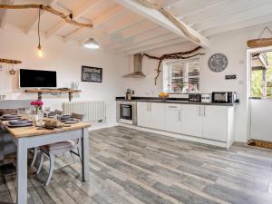 a kitchen with white cabinets and a table at 2 Bed in Swansea oc-78845 in Ilston +23 photos