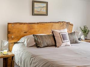 a bed with a wooden headboard and pillows on it at 2 Bed in Swansea oc-78845 in Ilston