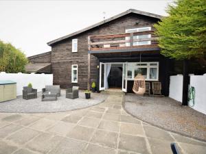 a house with a patio and chairs in front of it at 2 Bed in Swansea oc-78845 in Ilston